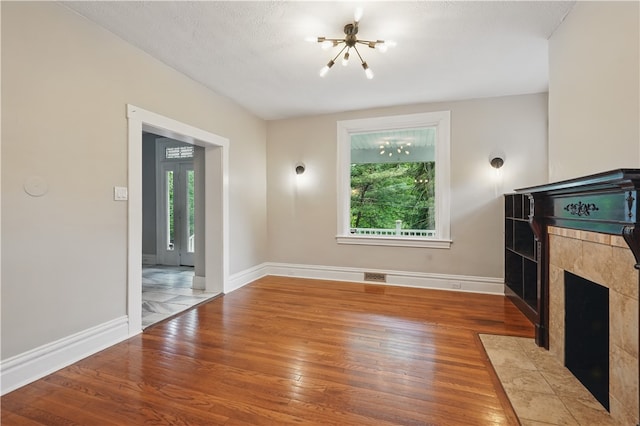 7504 Brighton Rd, Ben Avon, PA 15202 - unfurnished living room with a chandelier, hardwood / wood-style floors, and a fireplace