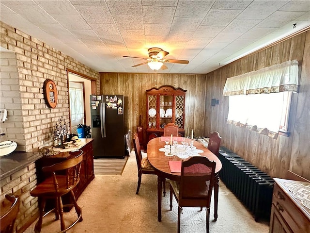 328 N Gallatin Ave, North Union Twp, PA 15401 - dining area featuring wood walls, ceiling fan, and brick wall