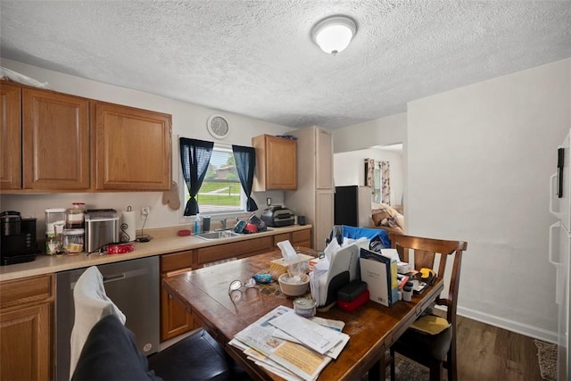 1153 Robinson Hwy, Robinson Twp Wsh, PA 15057 - kitchen with stainless steel dishwasher, wood finished floors, brown cabinetry, a textured ceiling, and light countertops