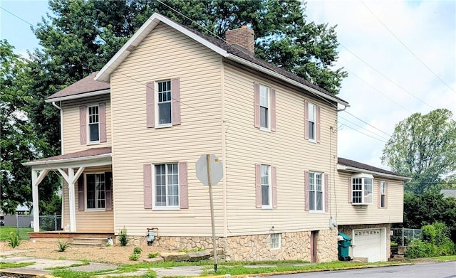 323 E 2nd St, Derry Boro, PA 15627 - view of side of property with a chimney, an attached garage, covered porch, and driveway