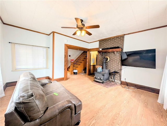 323 E 2nd St, Derry Boro, PA 15627 - living room with ceiling fan, a wood stove, stairway, ornamental molding, and wood finished floors