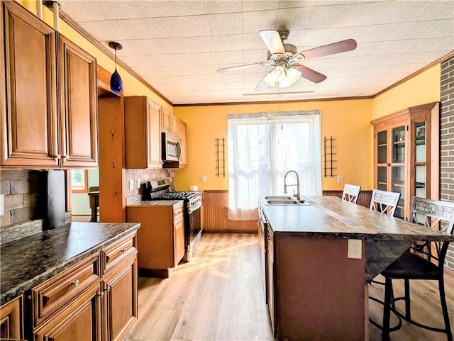 323 E 2nd St, Derry Boro, PA 15627 - kitchen with appliances with stainless steel finishes, crown molding, dark countertops, ceiling fan, and light wood-type flooring