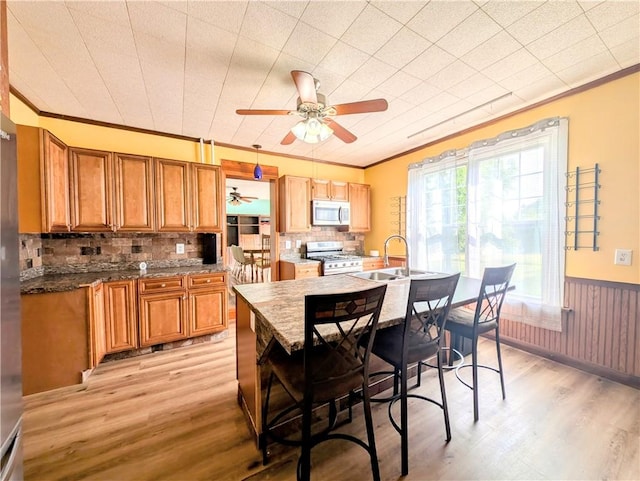 323 E 2nd St, Derry Boro, PA 15627 - kitchen featuring stainless steel appliances, crown molding, a ceiling fan, light wood-style flooring, and brown cabinets