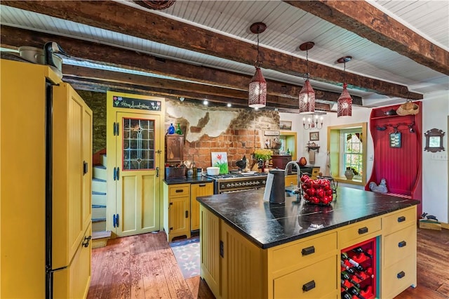 117 Havers Hill Rd, Jefferson/Mather, PA 15344 - kitchen featuring light wood-style flooring, dark countertops, a kitchen island with sink, a wooden ceiling with exposed beams, and cream cabinets