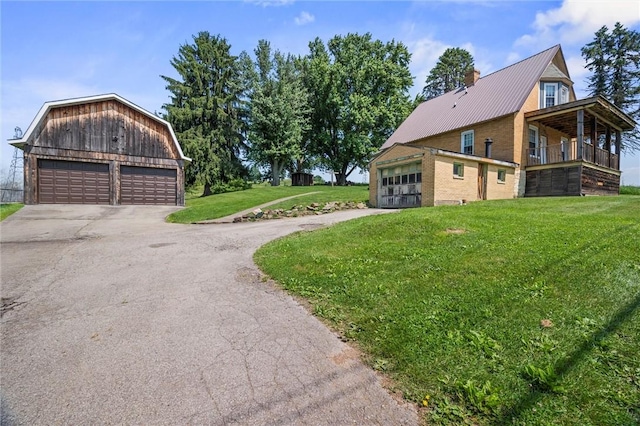 943 State Route 66, Gilpin Twp, PA 15690 - view of side of property with a yard, a detached garage, an outdoor structure, a chimney, and a metal roof