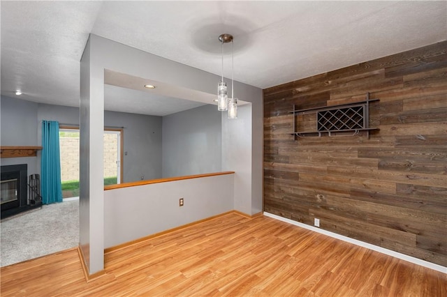 155 Spruce Ct, Ross Twp, PA 15229 - unfurnished dining area with wooden walls, wood finished floors, a glass covered fireplace, and recessed lighting