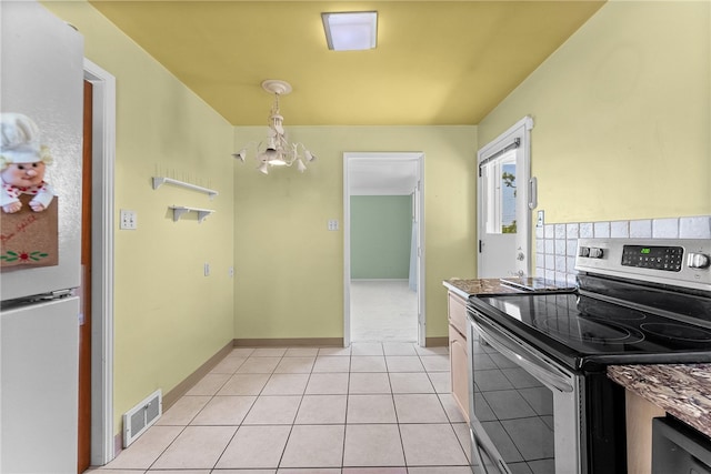 1228 Pinewood Dr, Mt Lebanon, PA 15243 - kitchen with stainless steel electric stove, freestanding refrigerator, a chandelier, light tile patterned floors, and hanging light fixtures