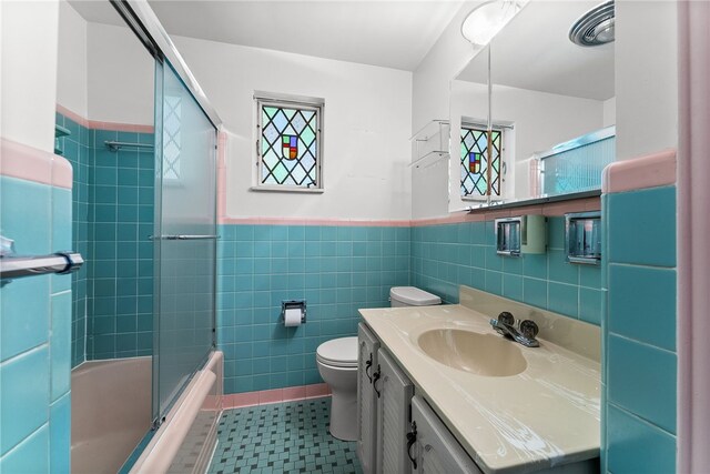 1228 Pinewood Dr, Mt Lebanon, PA 15243 - full bathroom with wainscoting, vanity, shower / bath combination with glass door, tile walls, and tile patterned floors