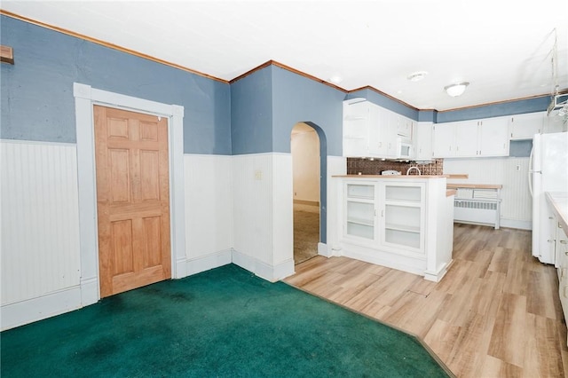 669 Franklin St, Cherryhll Twp/Clymer, PA 15728 - kitchen with arched walkways, radiator heating unit, white appliances, a wainscoted wall, and white cabinets