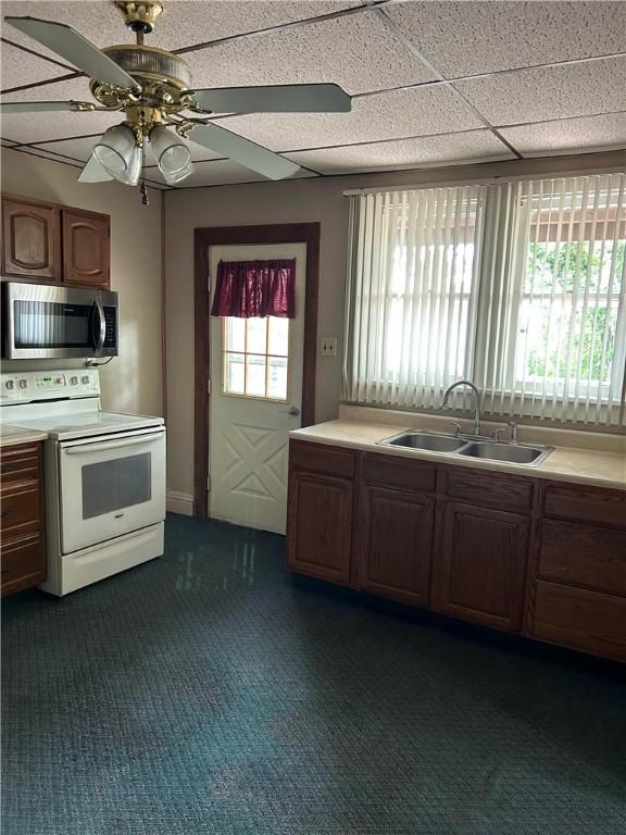 104 Whyle Ave, North Union Twp, PA 15401 - kitchen featuring stainless steel microwave, white range with electric stovetop, light countertops, and dark colored carpet