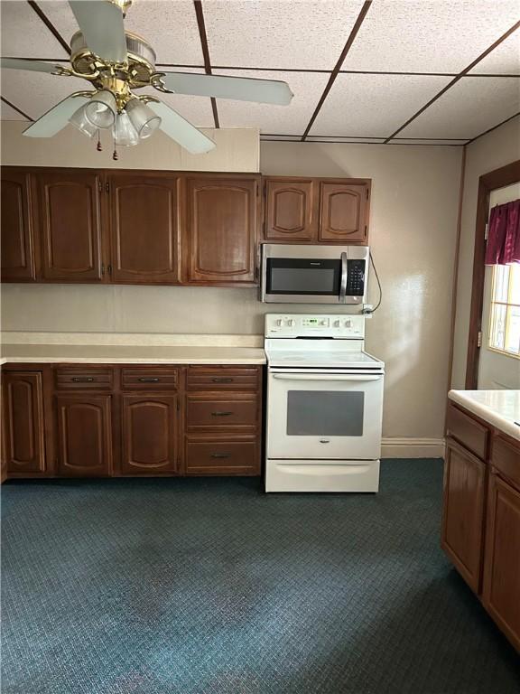 104 Whyle Ave, North Union Twp, PA 15401 - kitchen featuring stainless steel microwave, white range with electric cooktop, light countertops, dark carpet, and a paneled ceiling