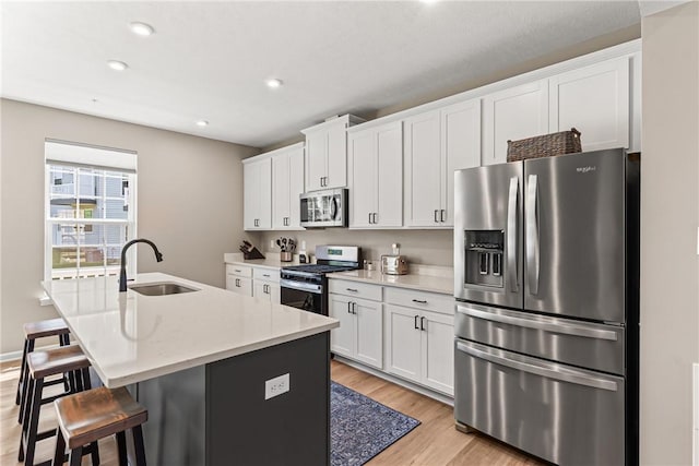 136 Sweetwater Dr, Moon/Crescent Twp, PA 15108 - kitchen with stainless steel appliances, light wood finished floors, an island with sink, white cabinetry, and recessed lighting