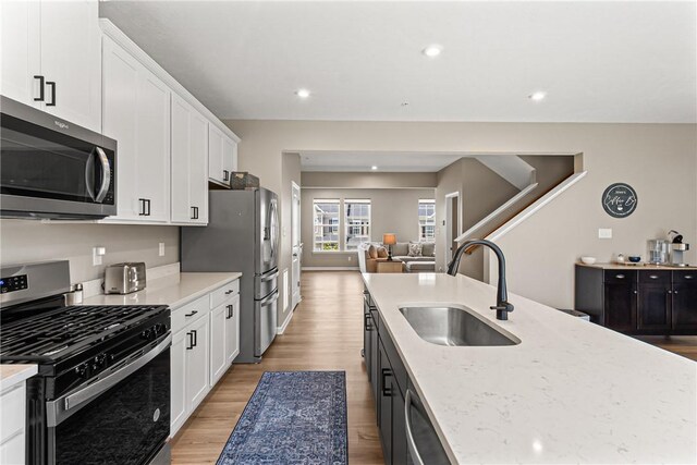 136 Sweetwater Dr, Moon/Crescent Twp, PA 15108 - kitchen featuring appliances with stainless steel finishes, open floor plan, light wood-style floors, white cabinetry, and recessed lighting