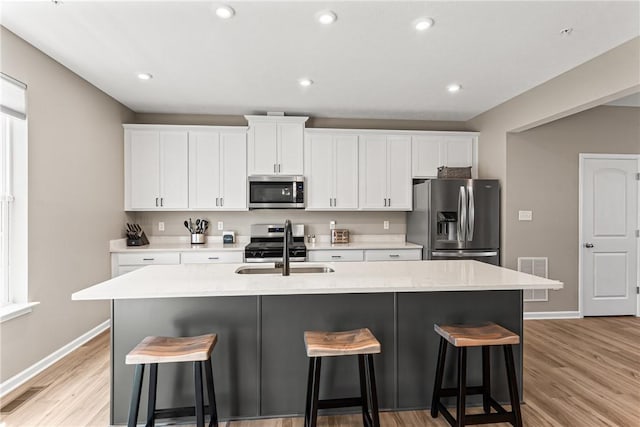 136 Sweetwater Dr, Moon/Crescent Twp, PA 15108 - kitchen featuring appliances with stainless steel finishes, a breakfast bar area, white cabinets, and recessed lighting