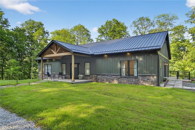 521 Creek Rd, Smith, PA 15019 - view of front of home with stone siding, a front yard, a standing seam roof, and a patio