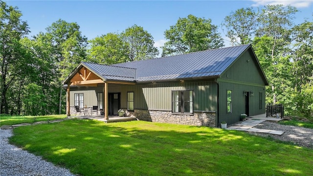 521 Creek Rd, Smith, PA 15019 - rear view of property featuring stone siding, a yard, a metal roof, a standing seam roof, and a patio area