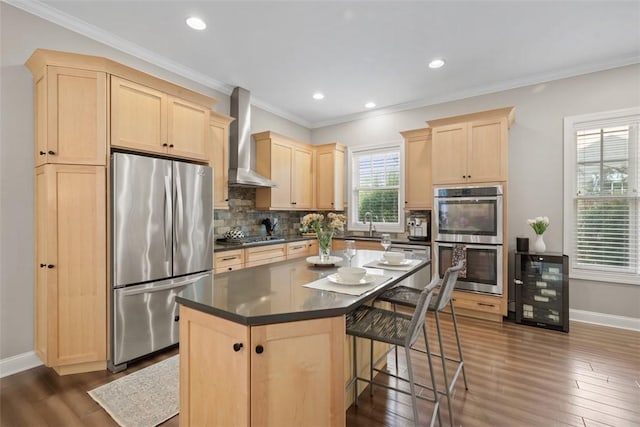 403 Cayuga Cir, Marshall, PA 16046 - kitchen featuring appliances with stainless steel finishes, light brown cabinetry, wall chimney exhaust hood, dark countertops, and a breakfast bar