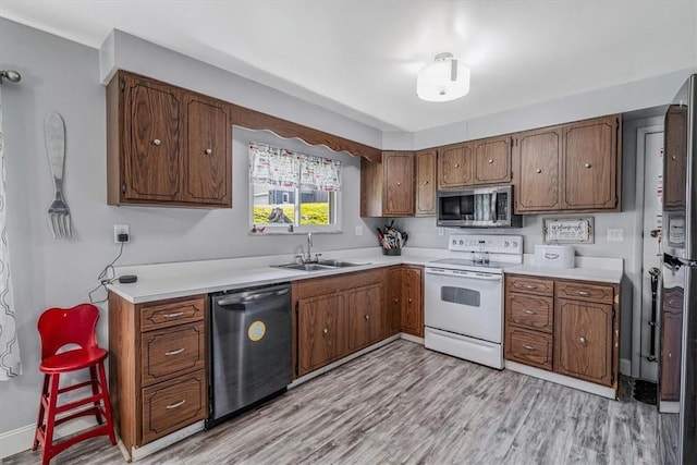 360 Jo Ann Dr, Monessen, PA 15062 - kitchen with dishwashing machine, white electric range, stainless steel microwave, light wood-type flooring, and light countertops
