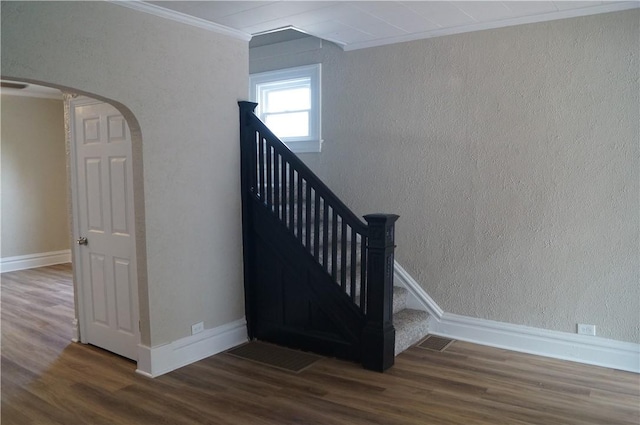 9 E Gaskill Ave, Jeannette, PA 15644 - staircase with crown molding, arched walkways, wood finished floors, and a textured wall