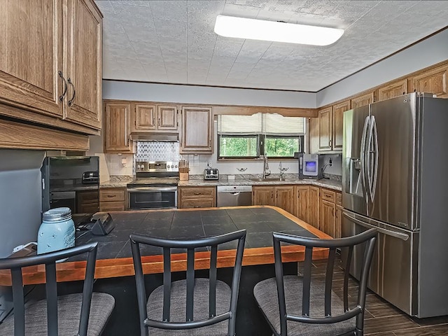 165 Monks Rd, Clinton Twp, PA 16056 - kitchen with appliances with stainless steel finishes, under cabinet range hood, a breakfast bar, and backsplash