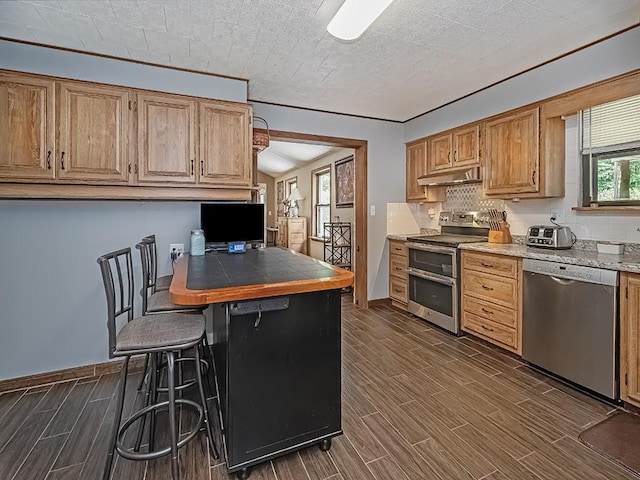 165 Monks Rd, Clinton Twp, PA 16056 - kitchen with stainless steel appliances, under cabinet range hood, wood tiled floors, a breakfast bar area, and a peninsula