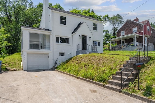 4736 Doyle Rd, Whitehall, PA 15227 - view of front facade with stairway, a garage, driveway, a chimney, and brick siding