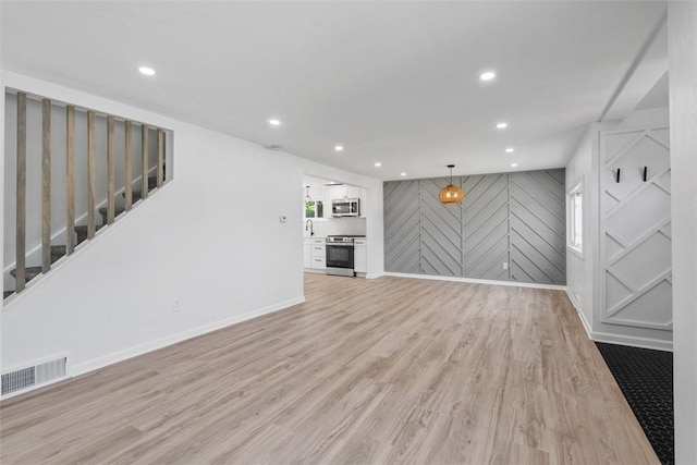 4736 Doyle Rd, Whitehall, PA 15227 - unfurnished living room with light wood-style floors, stairs, and recessed lighting