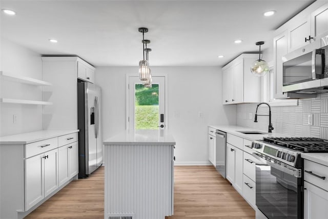 4736 Doyle Rd, Whitehall, PA 15227 - kitchen with stainless steel appliances, a kitchen island, decorative backsplash, light wood-style floors, and recessed lighting