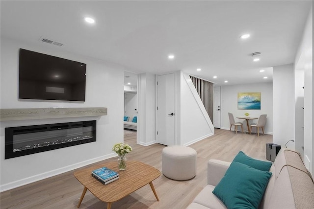 4736 Doyle Rd, Whitehall, PA 15227 - living area featuring wood finished floors, stairs, a glass covered fireplace, and recessed lighting