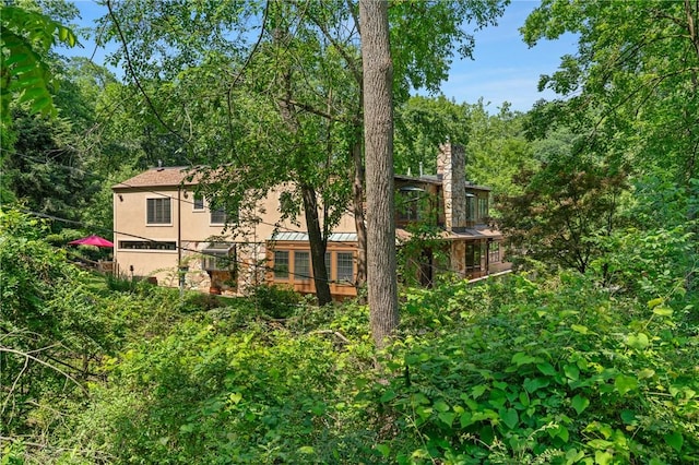 337 Fox Chapel Rd, Fox Chapel, PA 15238 - rear view of property featuring a standing seam roof, a forest view, a metal roof, and a chimney