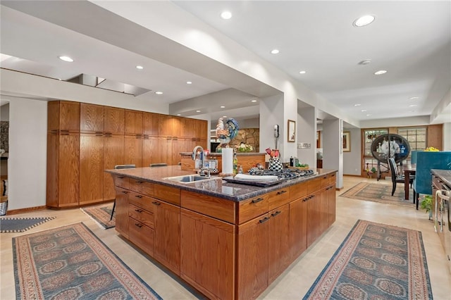 337 Fox Chapel Rd, Fox Chapel, PA 15238 - kitchen with dark stone counters, brown cabinetry, recessed lighting, open floor plan, and a kitchen island with sink