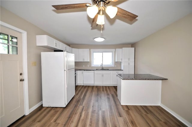 312 Delmont Ave, Coolbaugh Twp, PA 15012 - kitchen with white appliances, wood finished floors, white cabinetry, ceiling fan, and a peninsula