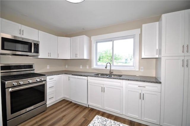 312 Delmont Ave, Coolbaugh Twp, PA 15012 - kitchen with appliances with stainless steel finishes, white cabinetry, wood finished floors, and dark stone countertops