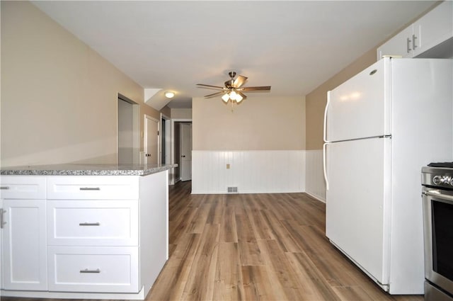 312 Delmont Ave, Coolbaugh Twp, PA 15012 - kitchen featuring a ceiling fan, stainless steel range oven, white cabinetry, light stone counters, and freestanding refrigerator