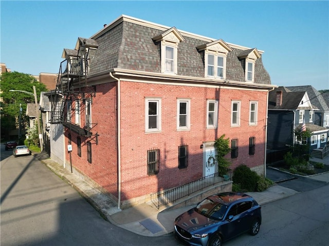 117 S Mckean St, City Of But Ne, PA 16001 - view of side of property featuring roof with shingles, mansard roof, and brick siding
