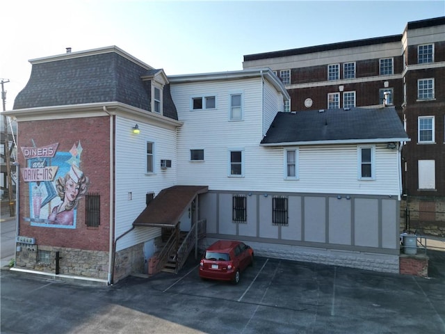 117 S Mckean St, City Of But Ne, PA 16001 - rear view of property featuring a shingled roof and uncovered parking