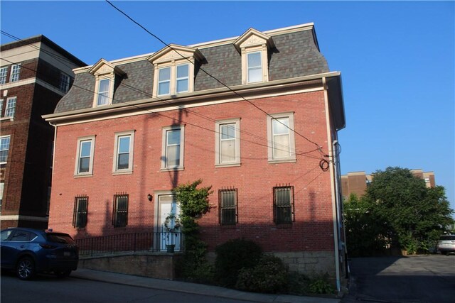 117 S Mckean St, City Of But Ne, PA 16001 - view of front of property featuring mansard roof, roof with shingles, and brick siding