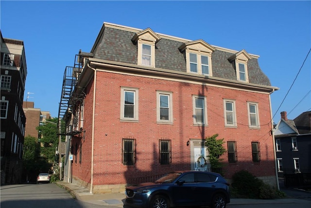 117 S Mckean St, City Of But Ne, PA 16001 - view of front of home featuring mansard roof, brick siding, and a shingled roof