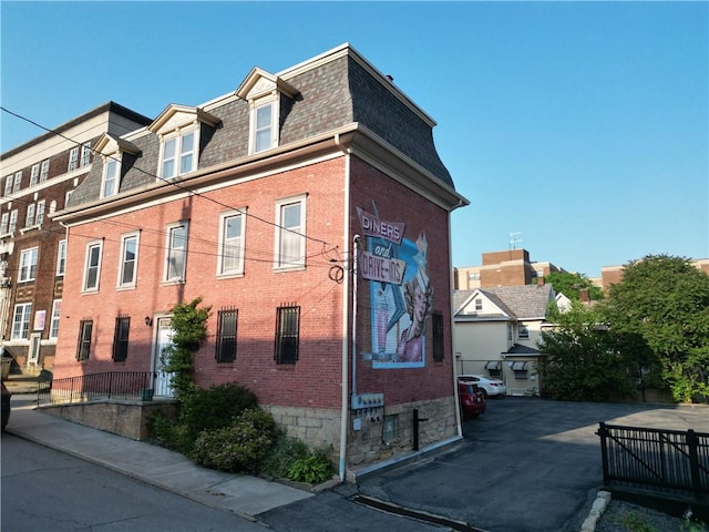 117 S Mckean St, City Of But Ne, PA 16001 - view of property exterior with a shingled roof, mansard roof, and brick siding