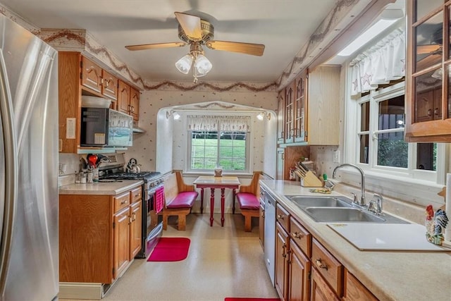 2509 Ridge Rd, Jefferson Hills, PA 15332 - kitchen with stainless steel appliances, light countertops, ceiling fan, glass insert cabinets, and brown cabinets