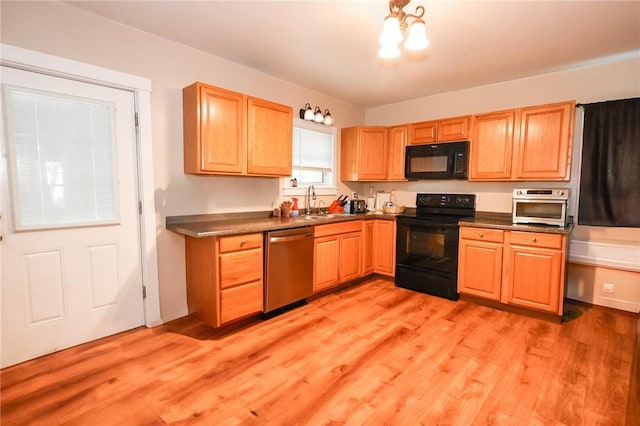 126 N Otter St, Mercer Boro Mer, PA 16137 - kitchen with black appliances, light wood-style floors, dark countertops, and a chandelier