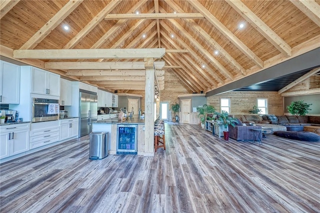 1060 Wattersonville Rd, Coolbaugh Twp, PA 16218 - kitchen with open floor plan, beverage cooler, appliances with stainless steel finishes, a wood ceiling with exposed beams, and high vaulted ceiling