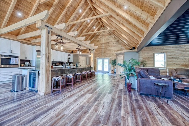 1060 Wattersonville Rd, Coolbaugh Twp, PA 16218 - living room with high vaulted ceiling, a wood ceiling with exposed beams, healthy amount of natural light, wood finished floors, and beverage cooler