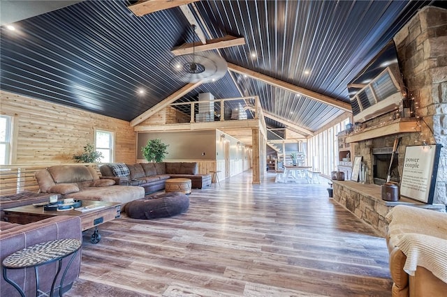 1060 Wattersonville Rd, Coolbaugh Twp, PA 16218 - living room with a wooden ceiling with exposed beams, wood finished floors, a stone fireplace, wooden walls, and high vaulted ceiling