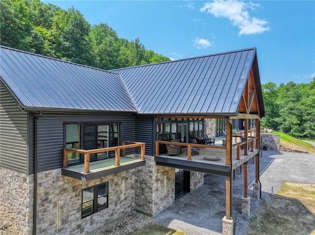 1060 Wattersonville Rd, Coolbaugh Twp, PA 16218 - rear view of property with stone siding, log veneer siding, a metal roof, and a standing seam roof