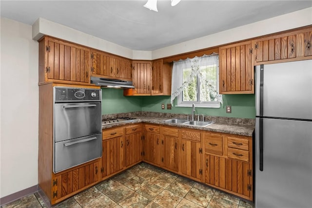 433 Wyndhurst Dr, Moon/Crescent Twp, PA 15108 - kitchen with stainless steel appliances, under cabinet range hood, brown cabinetry, and stone finish floors