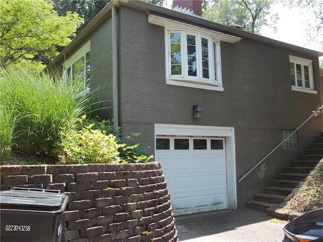 243 Byron Rd, Ross Twp, PA 15237 - view of side of property featuring an attached garage, a chimney, stairway, and driveway