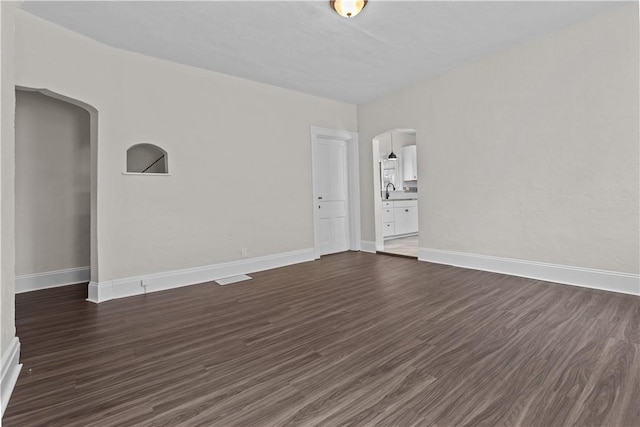 4506 Bowes Ave, West Mifflin, PA 15122 - unfurnished room with arched walkways and dark wood-style flooring