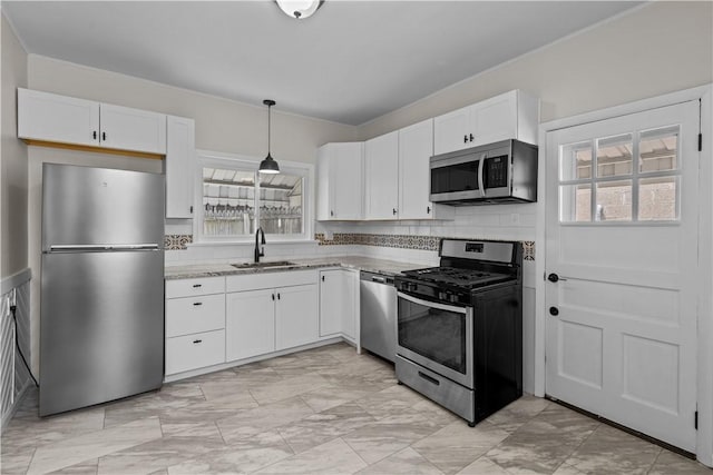 4506 Bowes Ave, West Mifflin, PA 15122 - kitchen with appliances with stainless steel finishes, white cabinetry, light stone counters, hanging light fixtures, and crown molding