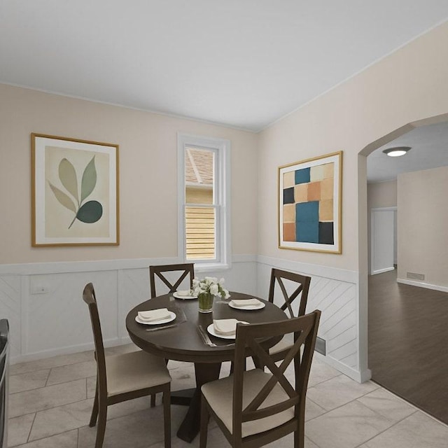 4506 Bowes Ave, West Mifflin, PA 15122 - dining room with arched walkways, wainscoting, light tile patterned flooring, and a decorative wall